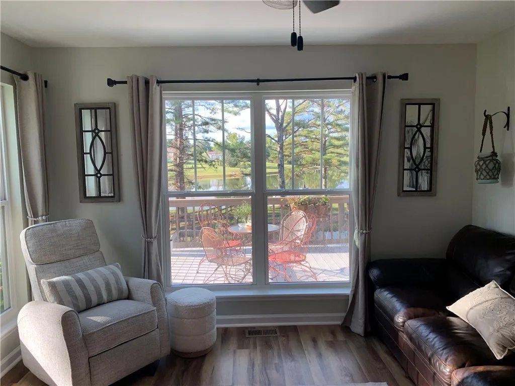 Expansive windows frame peaceful views of the water and surrounding greenery.