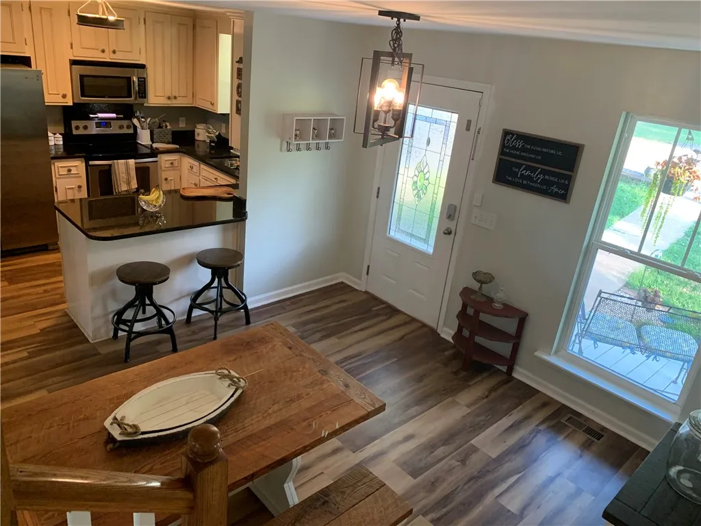 Gleaming wood-look floors anchor this open entry space leading directly into a fully equipped kitchen.