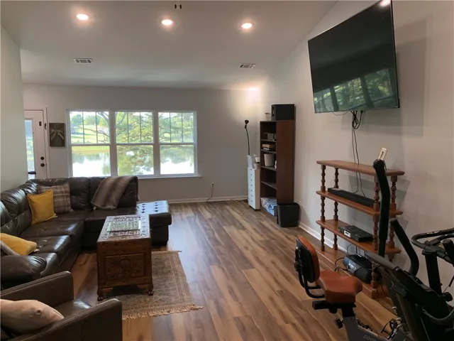 Rich wood floors and recessed lighting anchor this inviting living space overlooking the water.