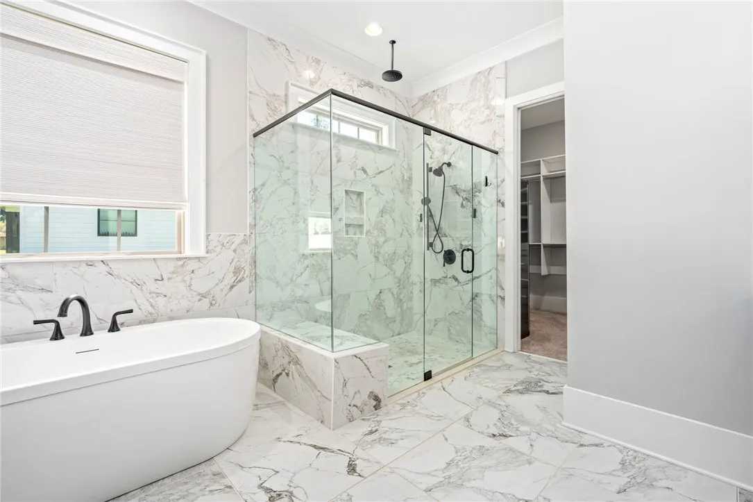 A glass-enclosed zero-entry shower and a freestanding soaking tub.