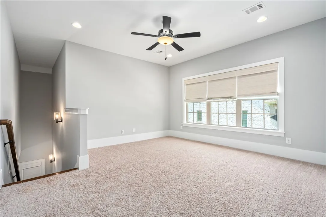 Plush carpeting and large windows define this versatile upper-level loft area.