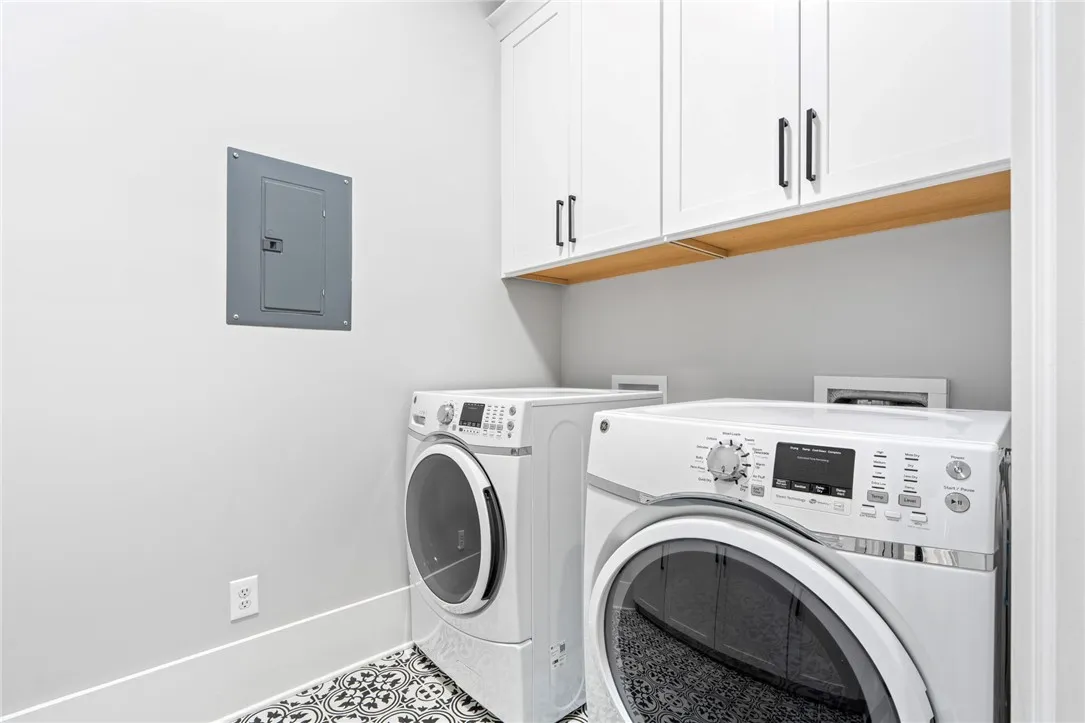 Custom cabinetry and patterned tile flooring elevate this highly functional laundry room.
