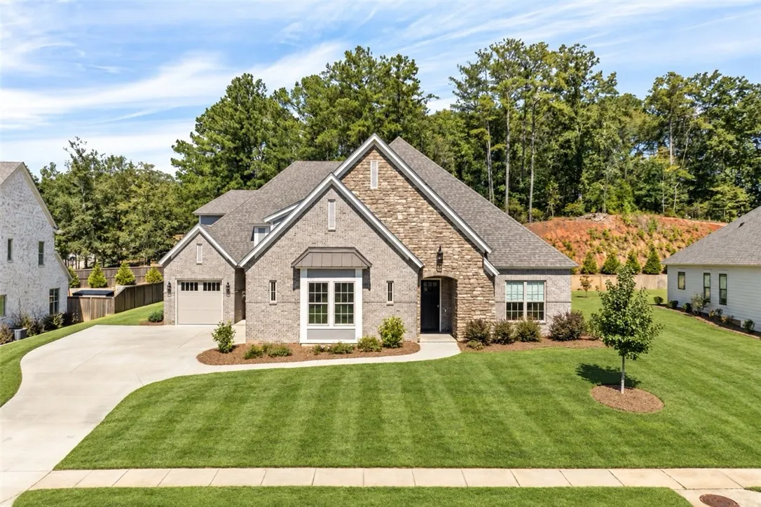 Exquisite brick and stone architecture pairs beautifully with manicured lawns and a spacious driveway.