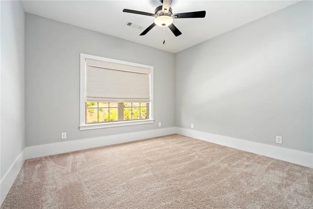 Soft carpeting pairs with a multi-pane window in this quiet secondary bedroom.