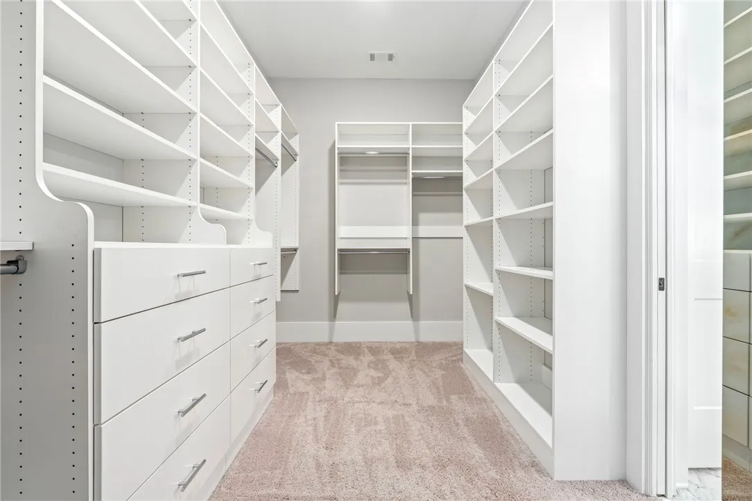 Ample built-in shelving and storage drawers maximize space in this meticulously designed walk-in closet.