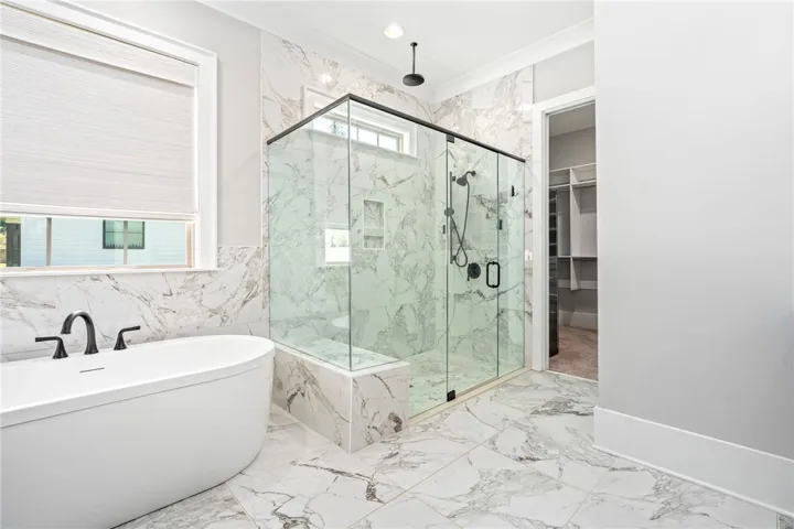 A glass-enclosed zero-entry shower and a freestanding soaking tub.