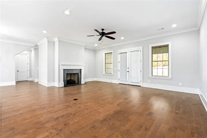 Warm engineered hardwood floors contrast with clean white trim and a classic fireplace.