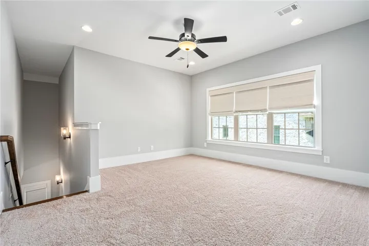 Plush carpeting and large windows define this versatile upper-level loft area.