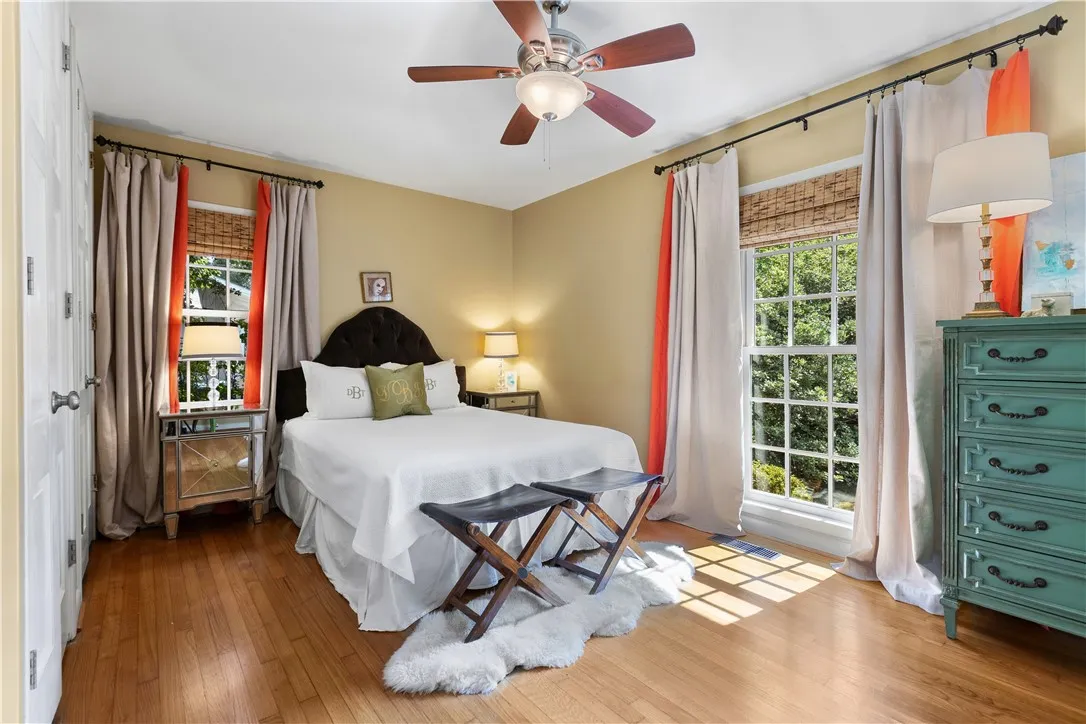 Rich hardwood flooring and classic windows define this primary bedroom retreat.