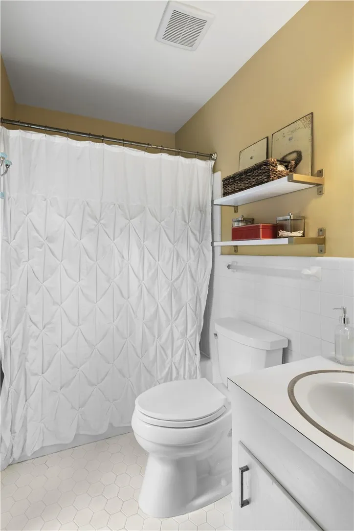 Crisp white wall tile and a clean vanity define this functional primary bath.