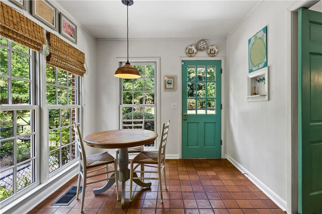 Terracotta tile floors pair with wood-framed windows overlooking the backyard.