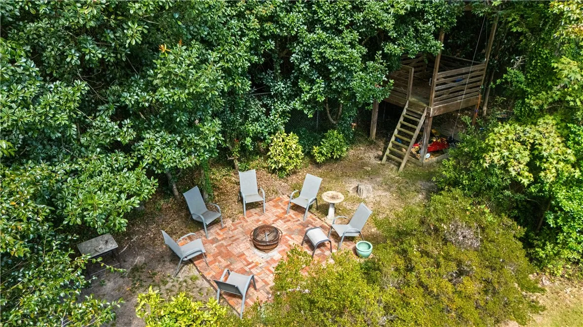 A nice fire pit area and fun tree house are located at the back of this large private yard.