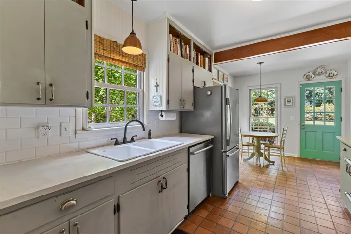Warm wood ceiling beam complements traditional tile flooring throughout this kitchen and adjacent breakfast room.