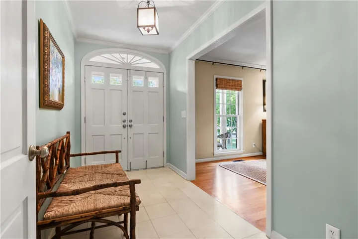 Elegant crown molding and classic tile flooring welcome guests into this light-filled entry foyer.