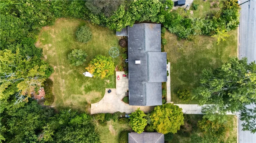 Mature trees surround this home, which sits on a generous green 0.49-acre lot.
