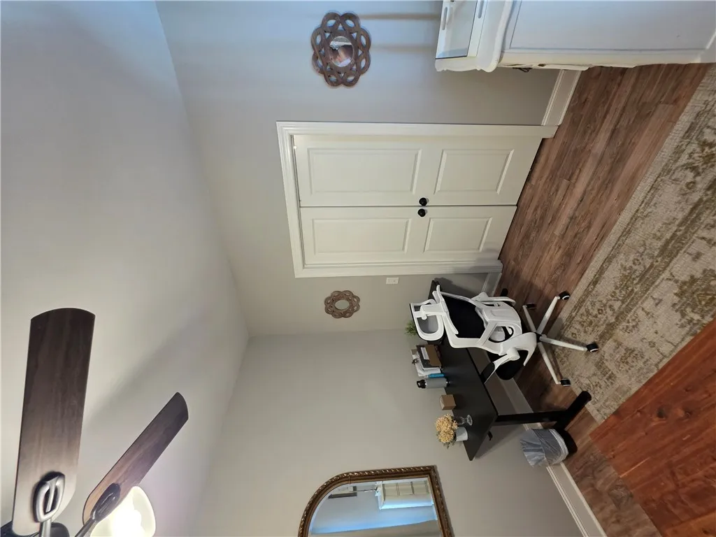 A versatile home office area features handsome wood flooring and a classic double-door closet.