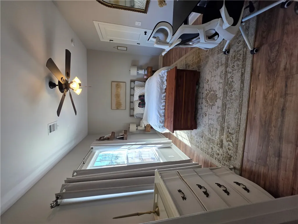 Gleaming hardwood floors and a classic multi-pane window elevate this comfortable bedroom design.