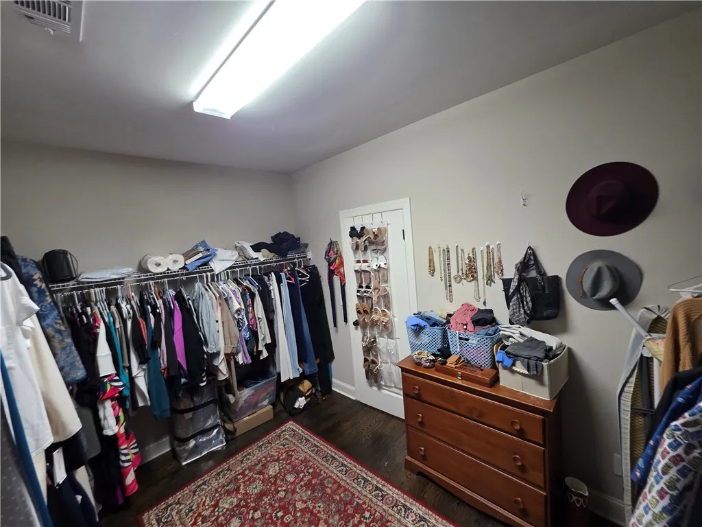 Ample hanging rods and smooth wood flooring define this functional walk-in closet space.