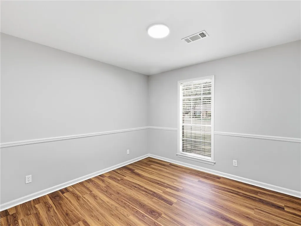 Rich wood flooring anchors this versatile space featuring classic chair rail molding.