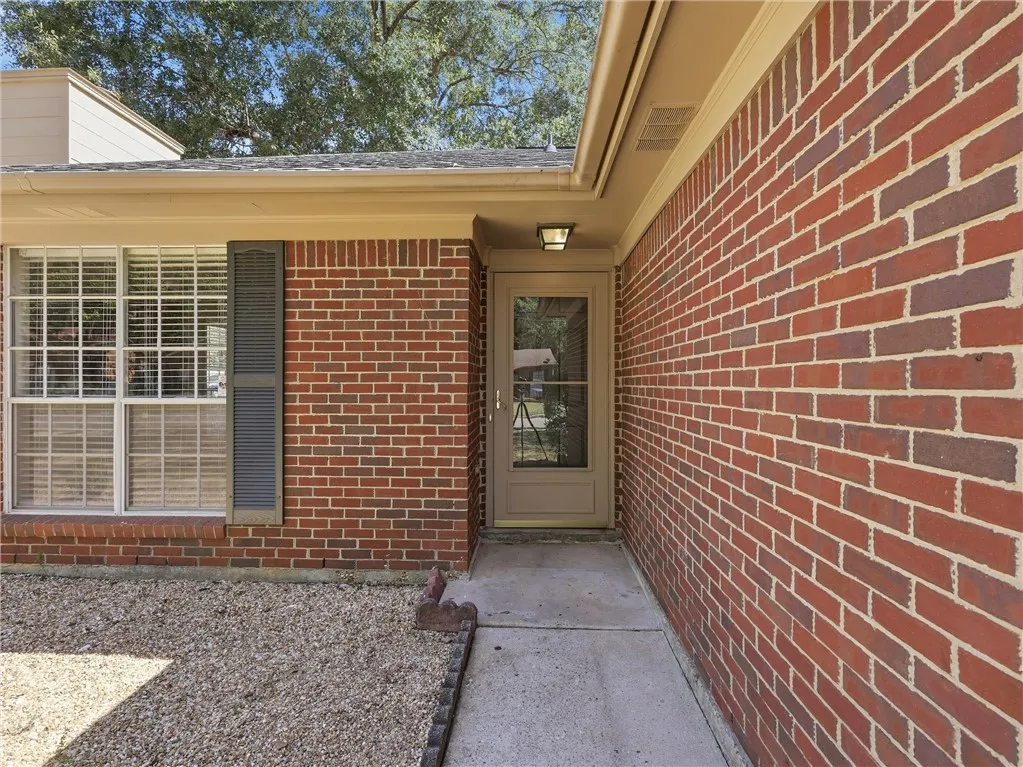 Classic brick accents frame a welcoming entryway set along a concrete pathway.
