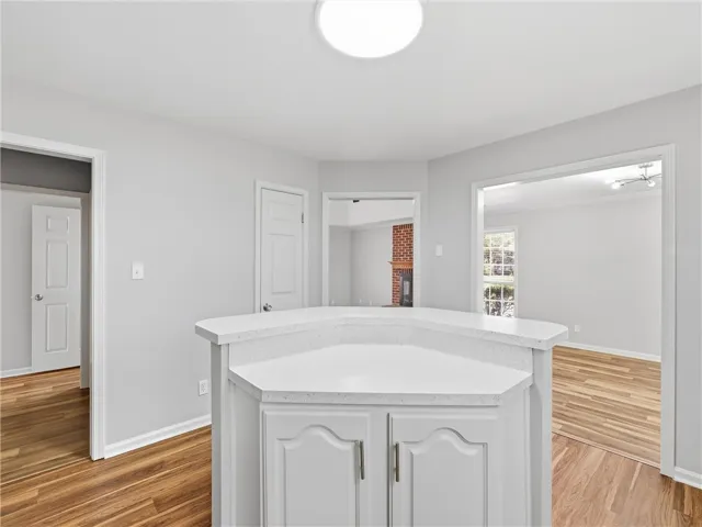 Rich wood flooring runs throughout this open space featuring a central island with stone counters.