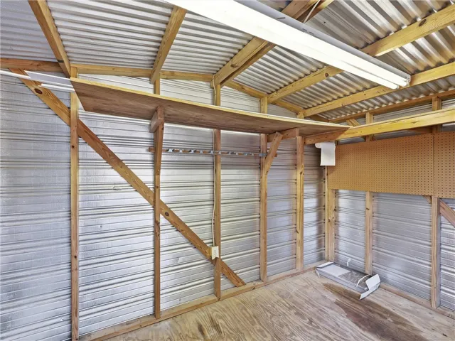 Functional outbuilding storage features sturdy wood shelving and a practical pegboard wall.