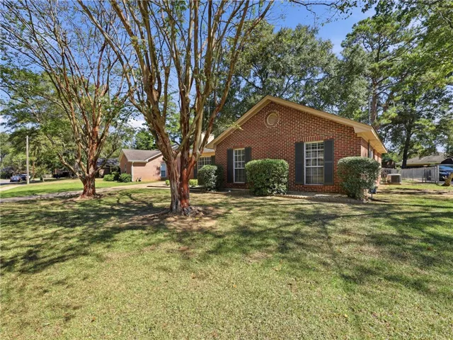 Mature trees shade the brick exterior of this classic ranch-style residence.