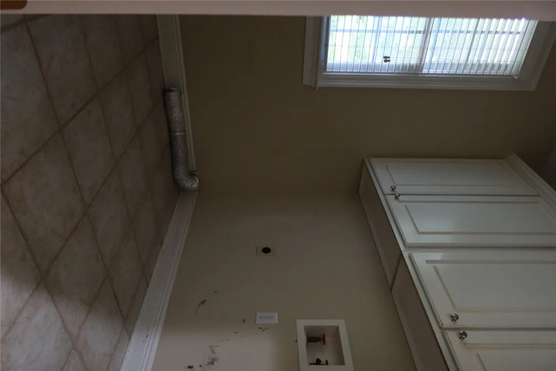 Tiled flooring and overhead cabinetry provide a practical foundation for home tasks.