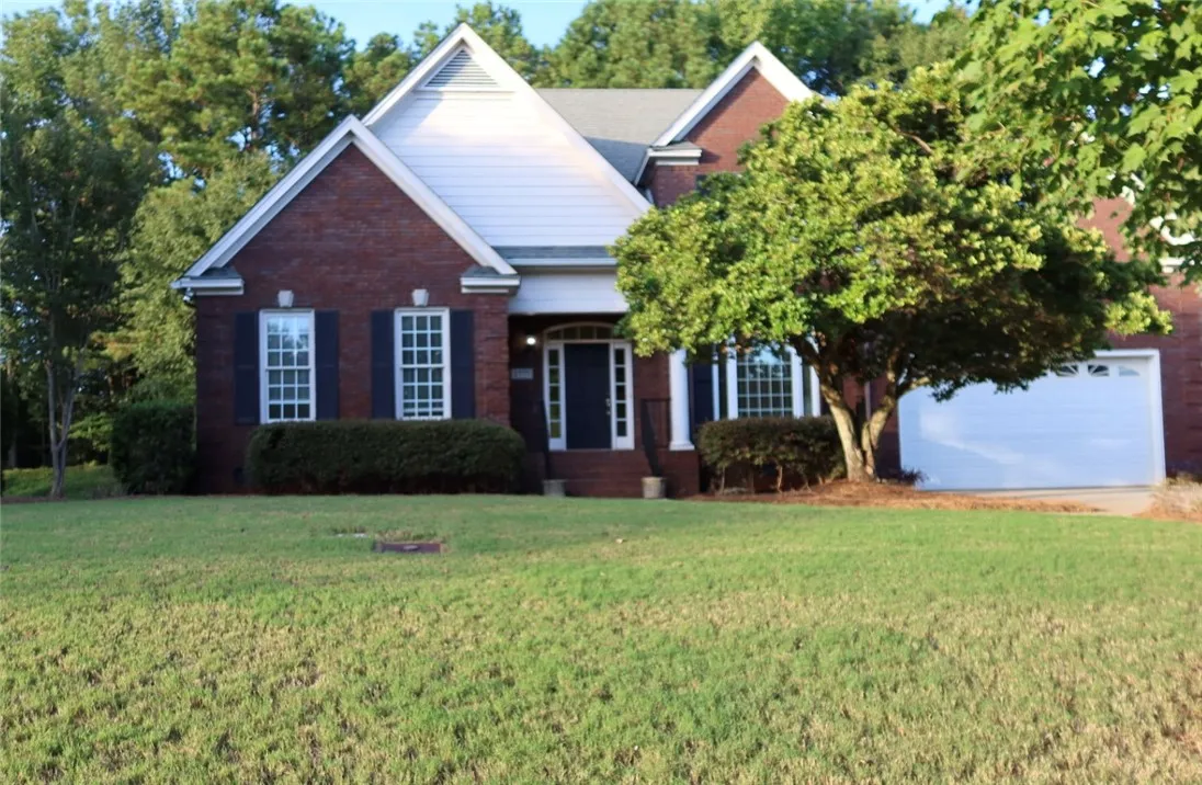 Stately brick construction defines this elegant home with a manicured front lawn.
