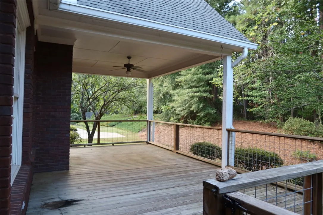 A spacious covered wooden deck overlooks the wooded backyard.