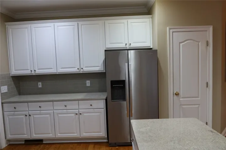 Gleaming stone countertops and classic crown molding accent this updated kitchen space.
