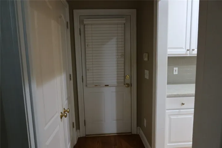 Warm hardwood floors connect a functional transition space to the adjacent kitchen area.