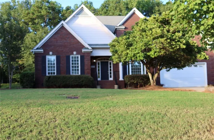 Stately brick construction defines this elegant home with a manicured front lawn.