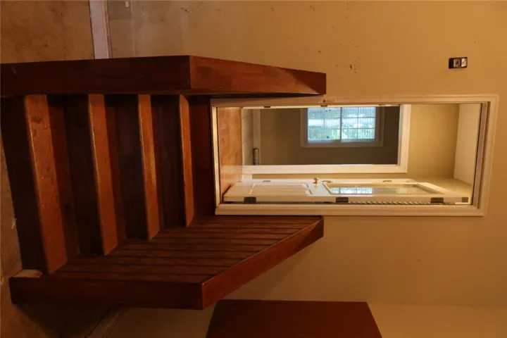 Rich wood stairs transition smoothly into garage.