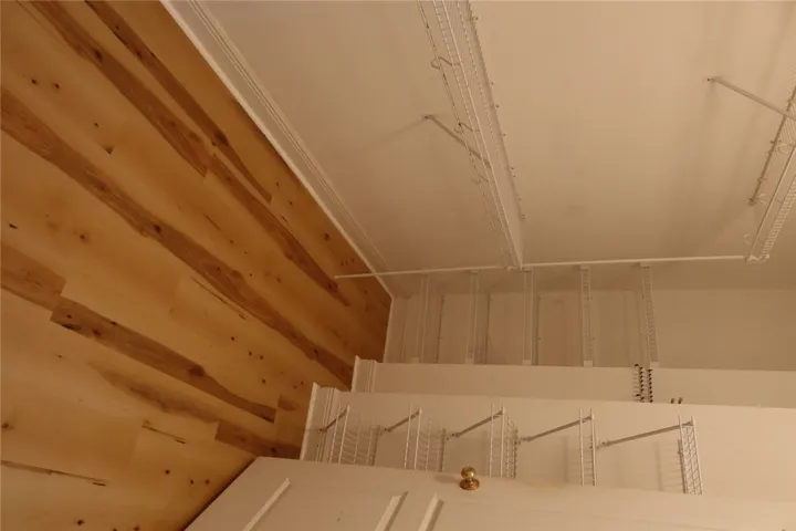 Ample wire shelving and rich wood flooring maximize storage capacity in this functional space.