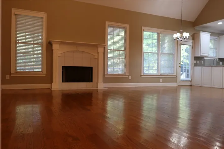 Gleaming hardwood floors and a classic fireplace anchor this open living space.