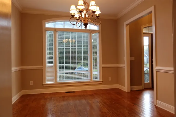 Gleaming hardwood floors and classic wainscoting define this inviting dining area.