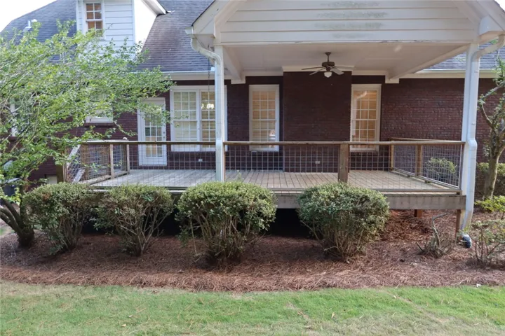 An elevated wooden deck extends from the brick exterior, offering a sheltered outdoor living space.