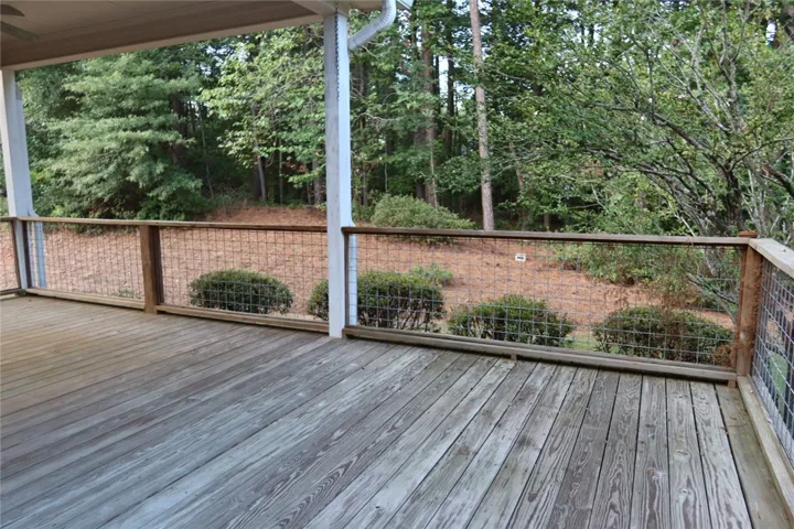 Mature woodlands provide a peaceful backdrop for this spacious covered deck.