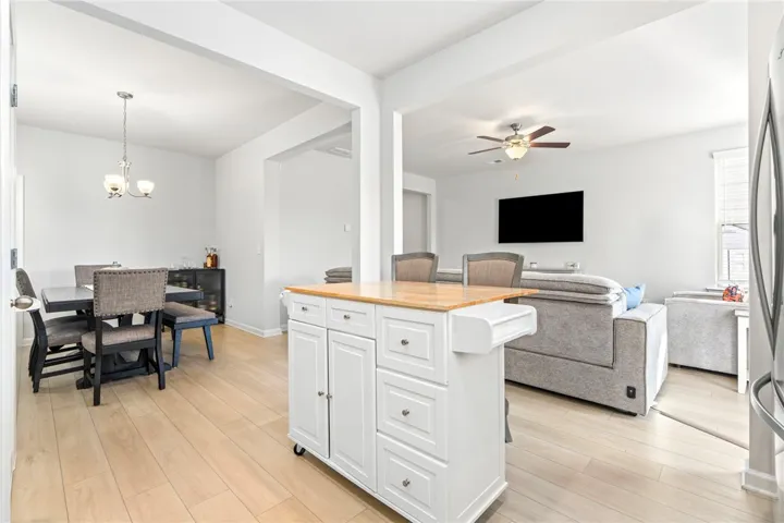 An open floor plan connects the living and dining areas seamlessly over smooth hardwood floors.