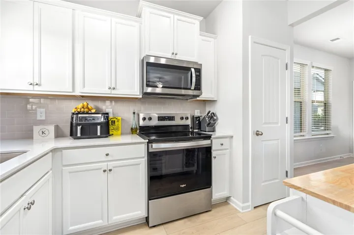 Crisp white cabinetry paired with modern stainless steel appliances creates an inviting culinary workspace.