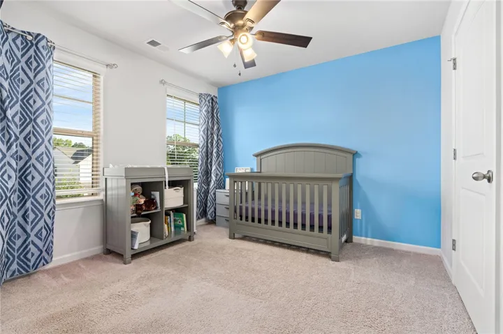 Plentiful natural light streams through multiple windows in this cozy bedroom.