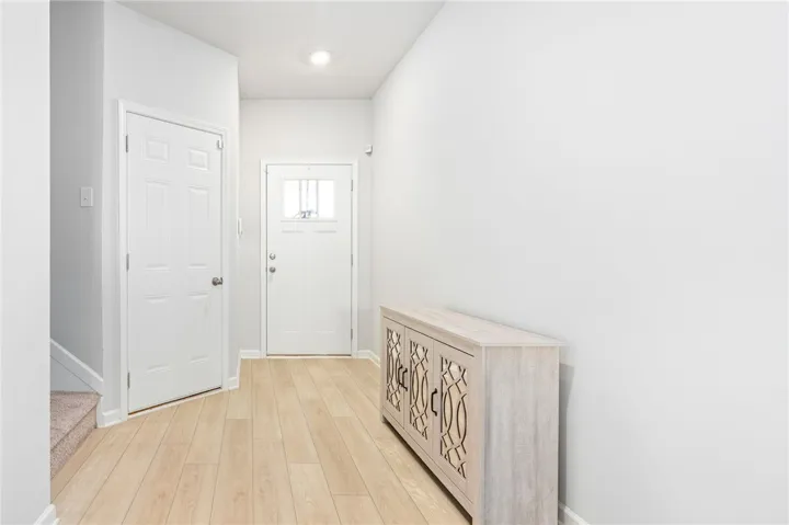 Smooth wood-look flooring and recessed lighting define this welcoming entry space.