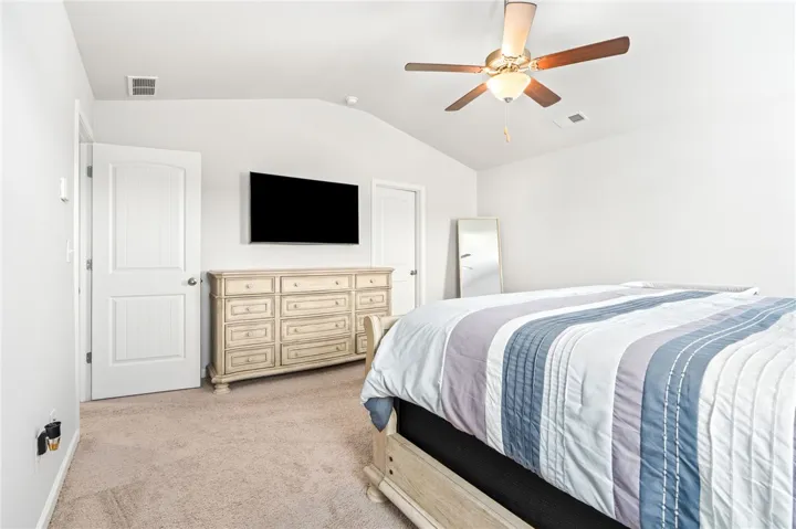 A vaulted ceiling and soft carpeting enhance this peaceful bedroom retreat.