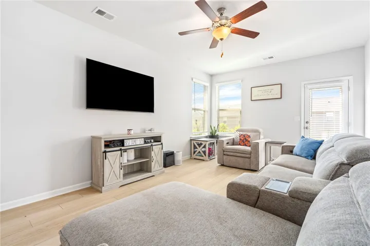 Smooth wood floors and tall windows define this open living area.