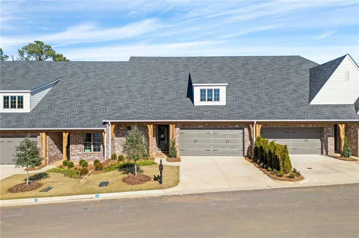 Classic brick accents and a spacious concrete driveway highlight this welcoming townhouse exterior.