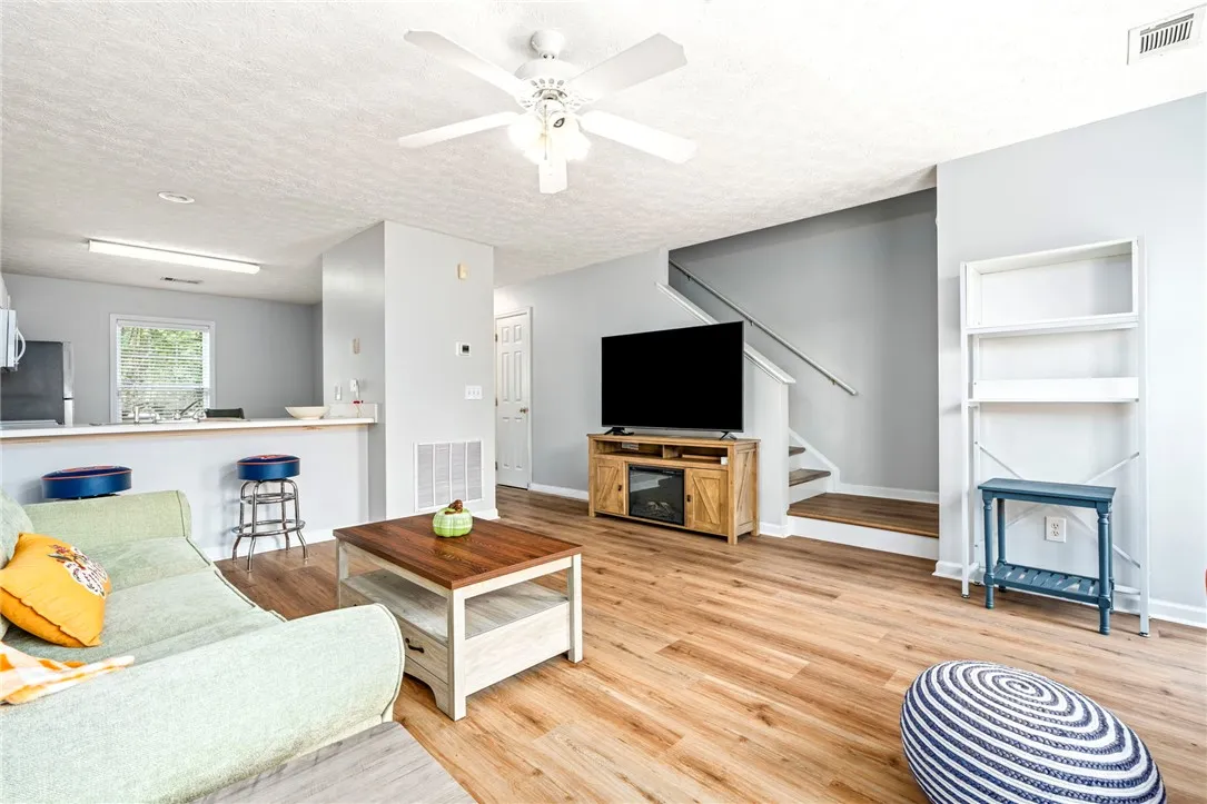 Warm wood-look flooring connects this inviting living space directly to the kitchen area.