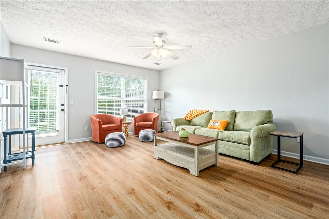 Rich wood-look flooring and generous natural light create an inviting living space.