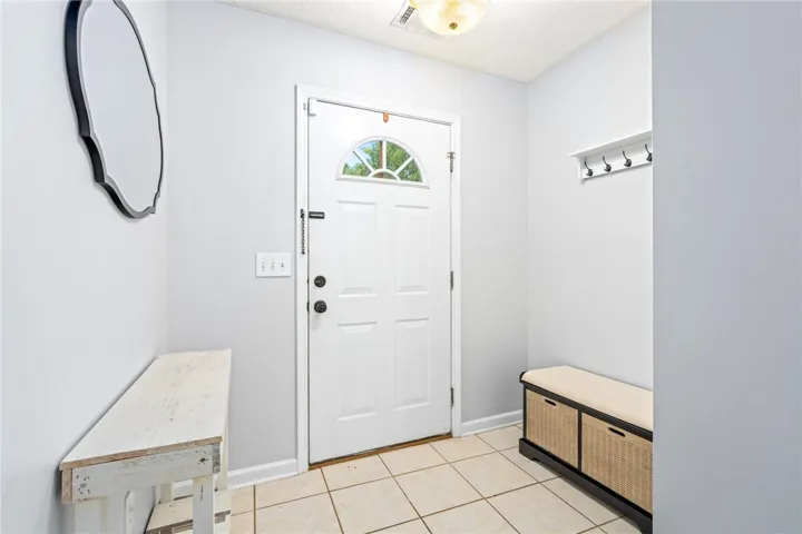 Tiled flooring and a classic paneled front door greet visitors in the welcoming entryway.