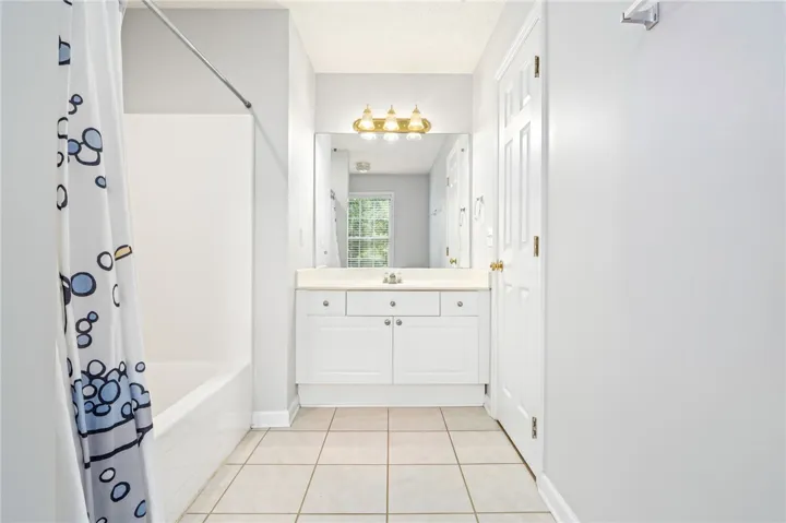 Tiled flooring and a crisp white vanity complete this functional bathroom space.